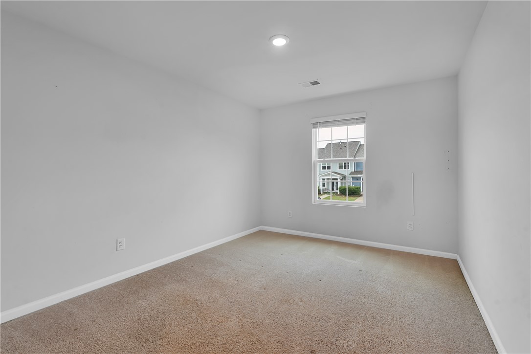 8 Leander Drive Greer, SC 29651 - Photo 28 of 31 A well-lit bedroom features plush carpet and a window offering a community view.