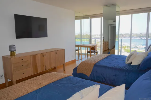 a bedroom with two beds and a flat screen tv