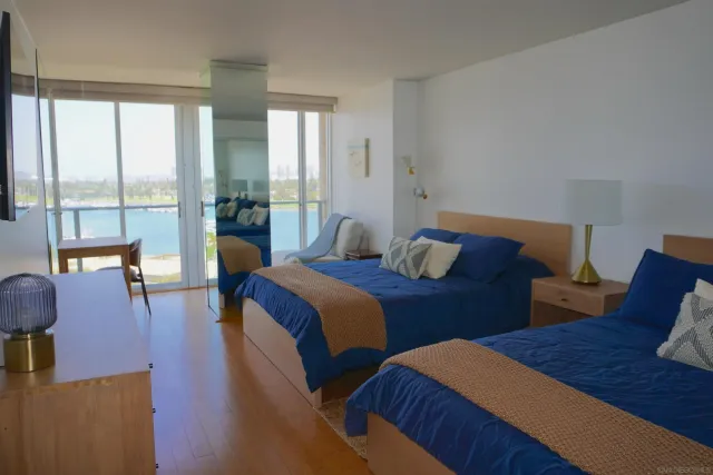 a bedroom with two beds and large glass windows
