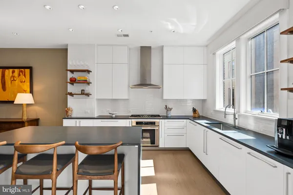 a kitchen with stainless steel appliances granite countertop a refrigerator and a stove