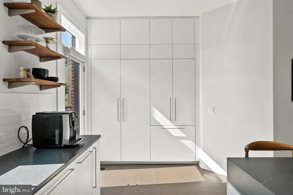 a large white kitchen with lots of counter space and wooden floor