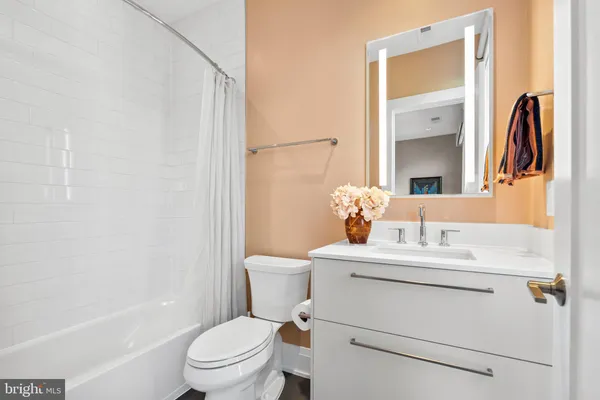 a bathroom with a granite countertop sink a toilet and shower