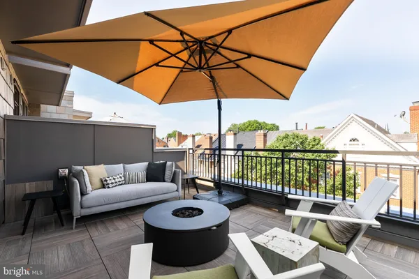 a view of a patio with couches table and chairs and potted plants