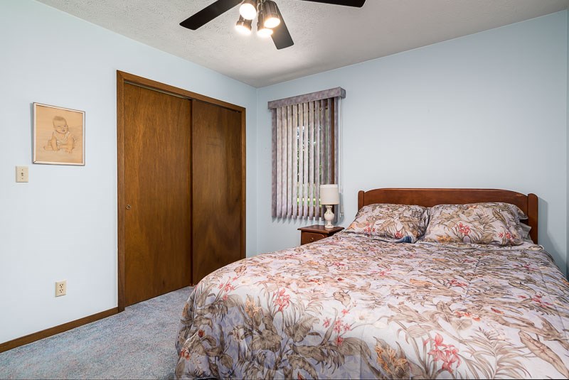 3644 Cutty Sark Road Cherry Valley, IL 61016 - Photo 19 of 33 a bedroom with a large bed and a chandelier