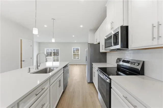 a kitchen with kitchen island granite countertop a sink and stove top oven