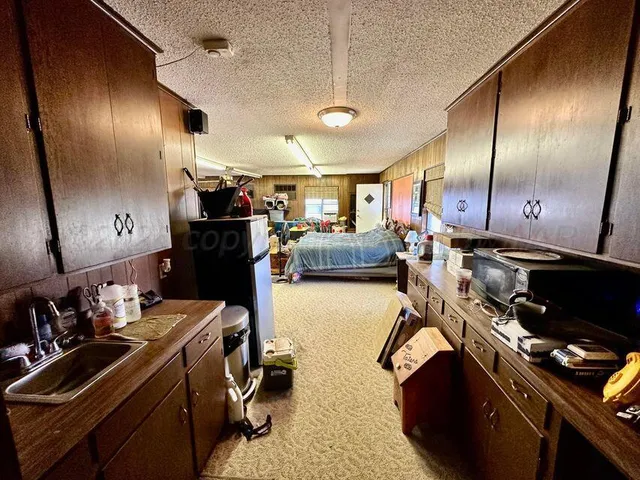 a view of a chair and table in backyard of potted plants