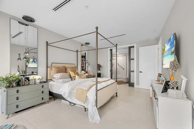 a bedroom with a bed mirror and window