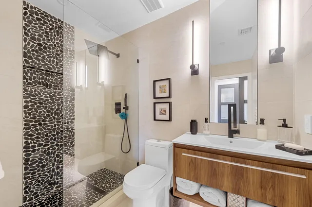 a bathroom with a sink a toilet and shower