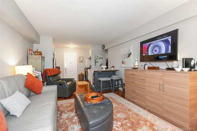 a living room with furniture kitchen view and a window