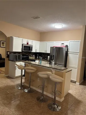 a kitchen with kitchen island a stove a sink and a refrigerator