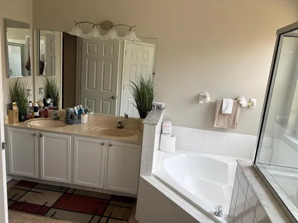 a bathroom with a double vanity sink a mirror and a bathtub