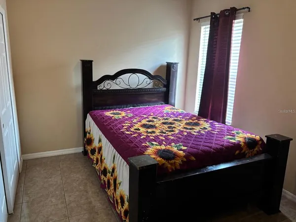a bed sitting in a bedroom next to a window
