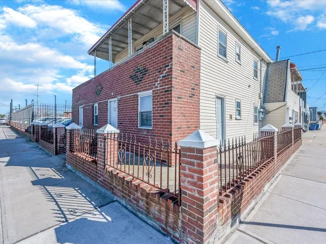 a view of a brick house with wooden fence