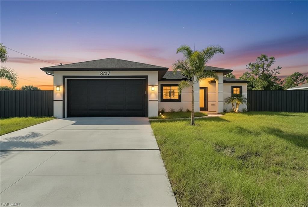 a front view of a house with a yard and garage
