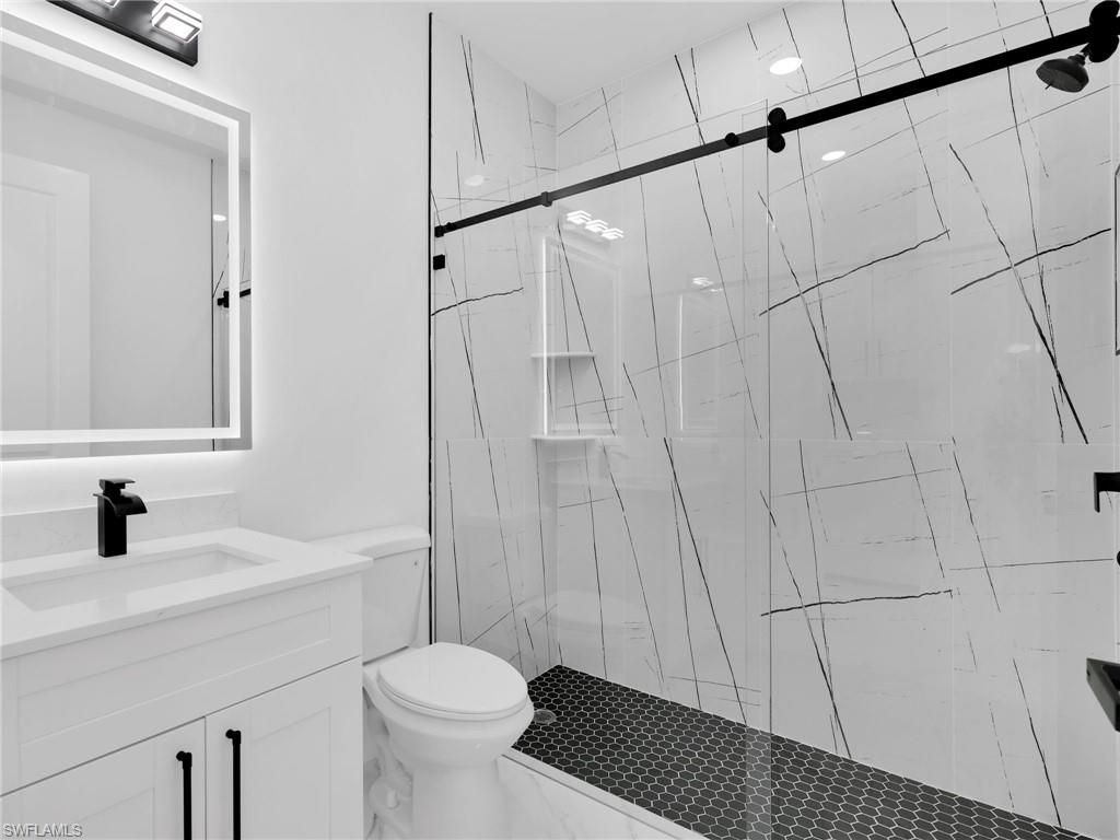 3417 8th Street Southwest Lehigh Acres, FL 33976 - Photo 17 of 32 a bathroom with a sink a toilet and shower