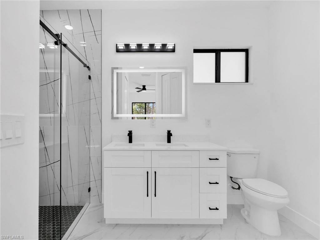 3417 8th Street Southwest Lehigh Acres, FL 33976 - Photo 22 of 32 a bathroom with a sink a toilet and mirror