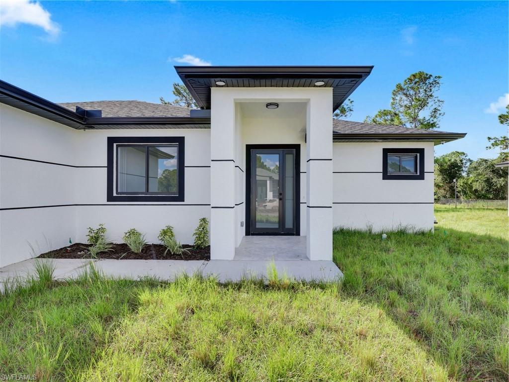 3417 8th Street Southwest Lehigh Acres, FL 33976 - Photo 3 of 32 a front view of a house with a yard