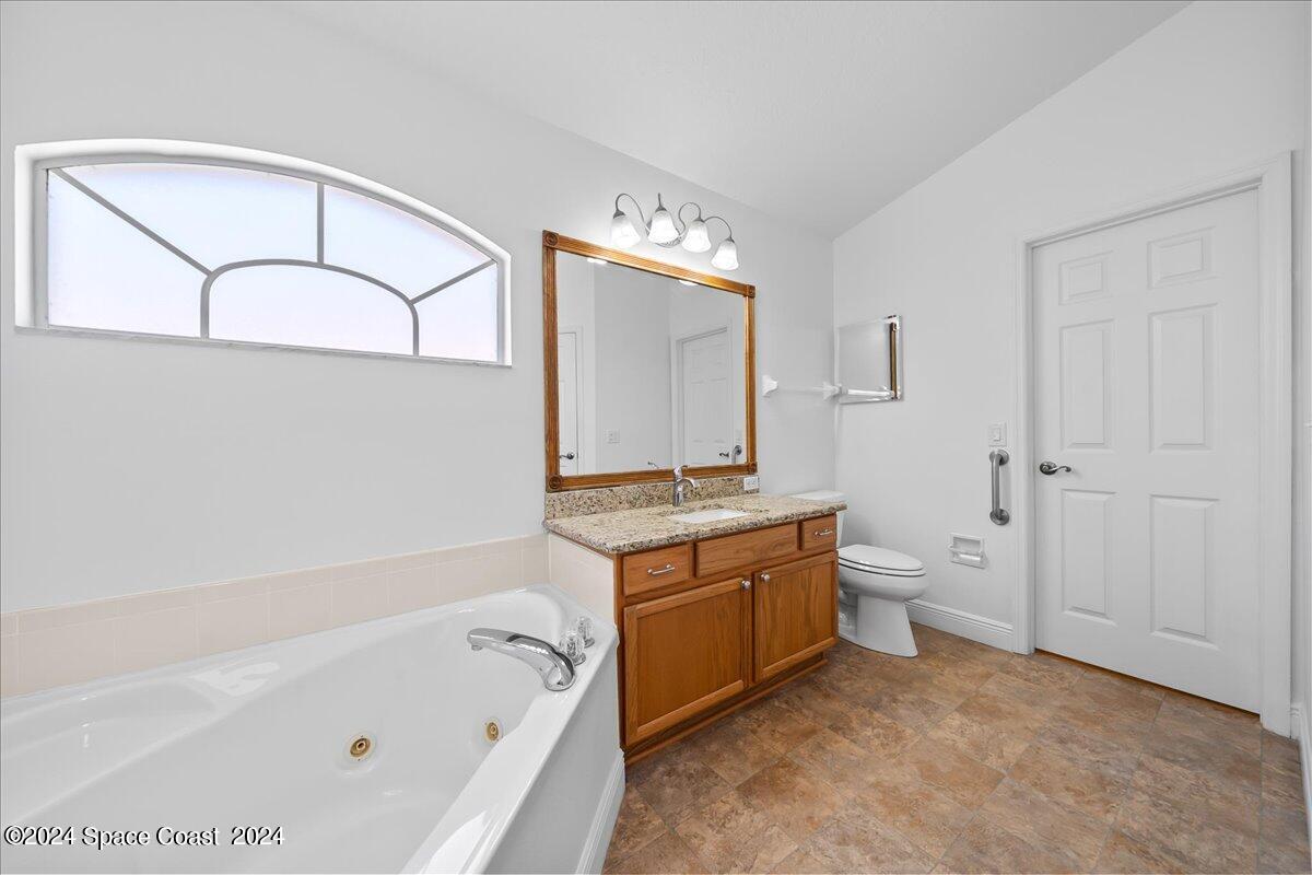 432 Stonehenge Circle Rockledge, FL 32955 - Photo 24 of 41 a bathroom with a granite countertop sink a toilet and bathtub