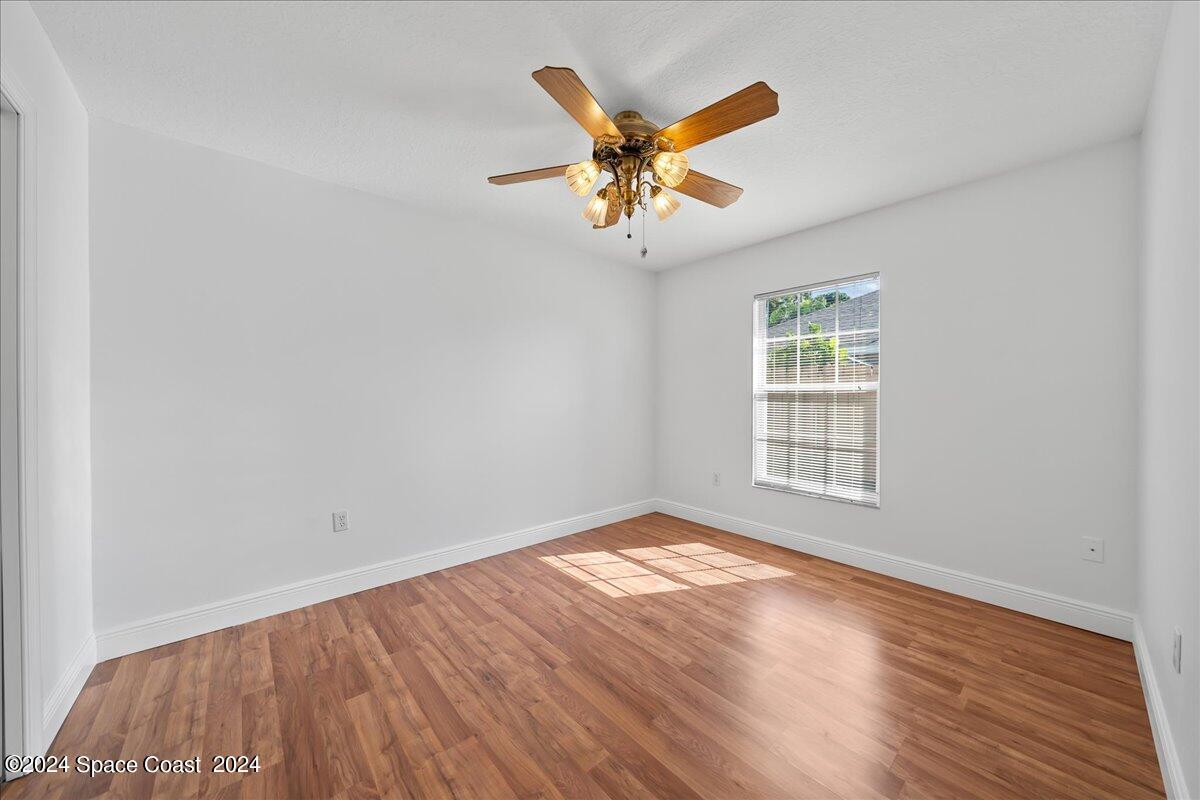 432 Stonehenge Circle Rockledge, FL 32955 - Photo 26 of 41 an empty room with wooden floor fan and windows