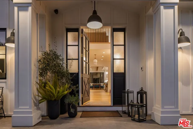 a living room with a hallway and a chandelier