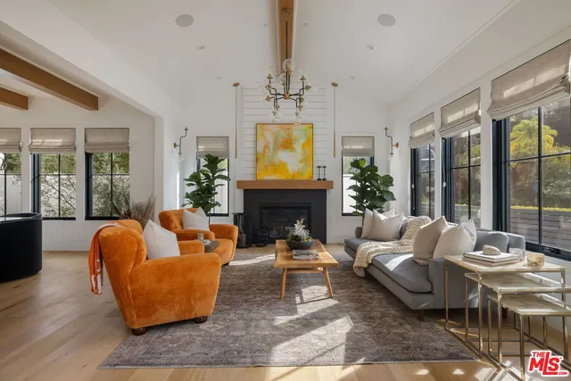 a living room with fireplace furniture and a large window