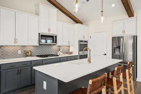 a kitchen with kitchen island a sink appliances and cabinets