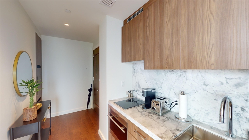 40 Trinity Place, Unit 1605 Boston, MA 02116 - Photo 4 of 16 a kitchen with stainless steel appliances a sink a counter space and a window