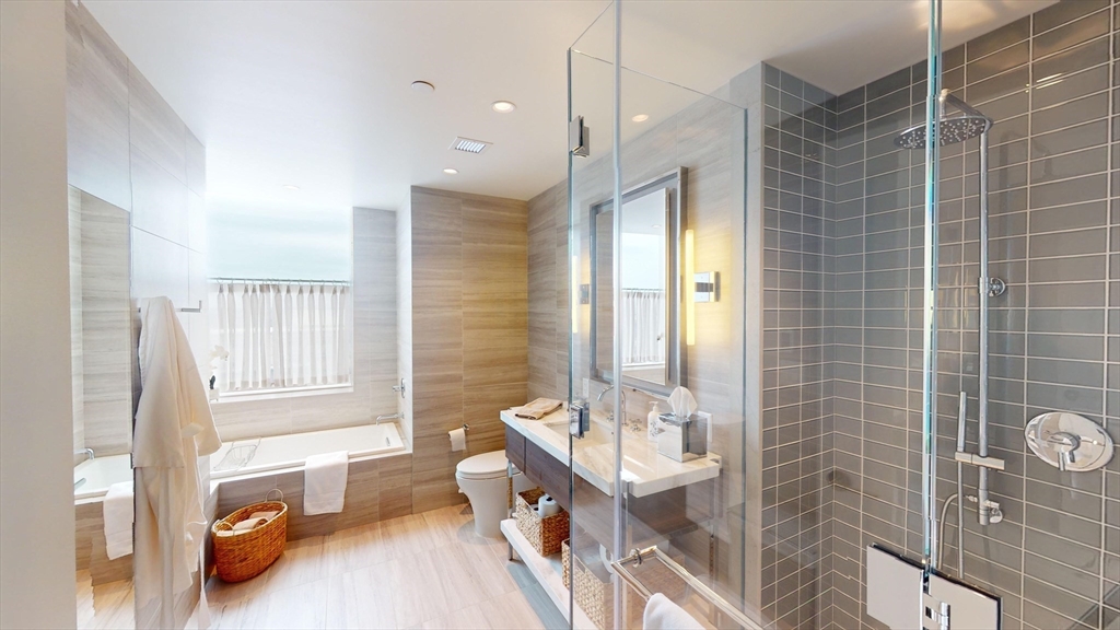 40 Trinity Place, Unit 1605 Boston, MA 02116 - Photo 7 of 16 a bathroom with a tub sink and mirror