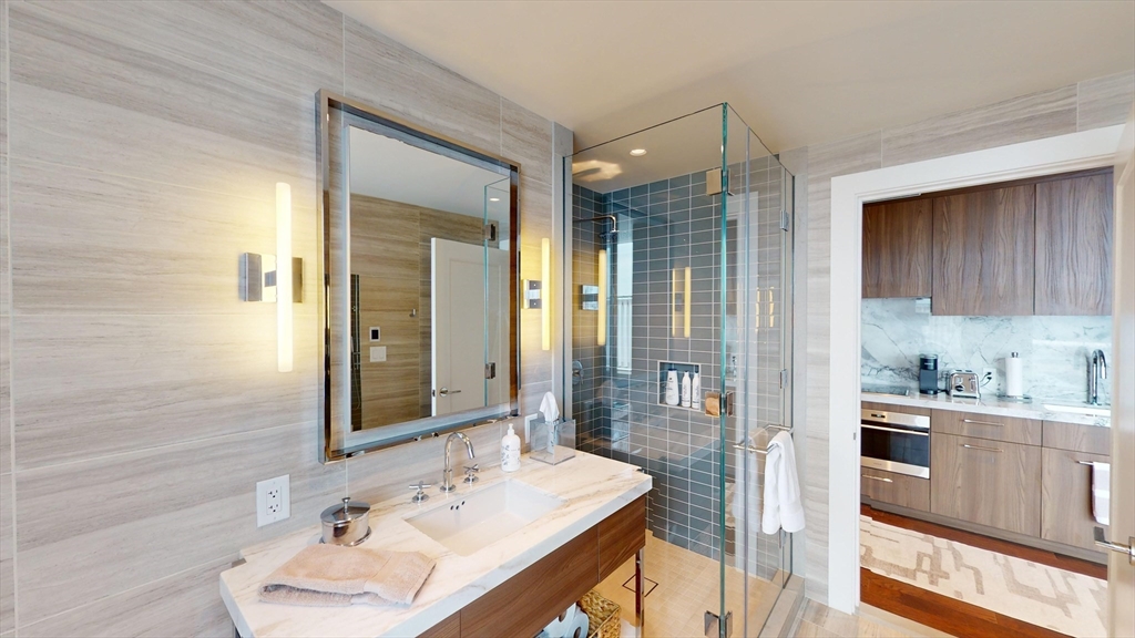 40 Trinity Place, Unit 1605 Boston, MA 02116 - Photo 8 of 16 a bathroom with a sink a mirror and a shower