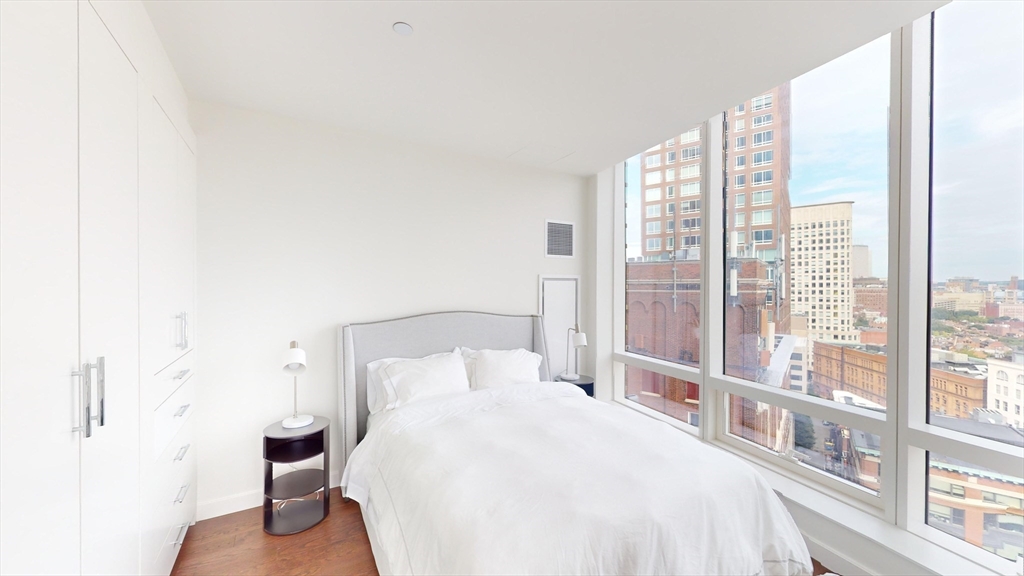 40 Trinity Place, Unit 1605 Boston, MA 02116 - Photo 9 of 16 a bedroom with a bed and a large window