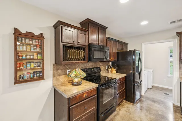 a kitchen with stainless steel appliances granite countertop a stove refrigerator and cabinets