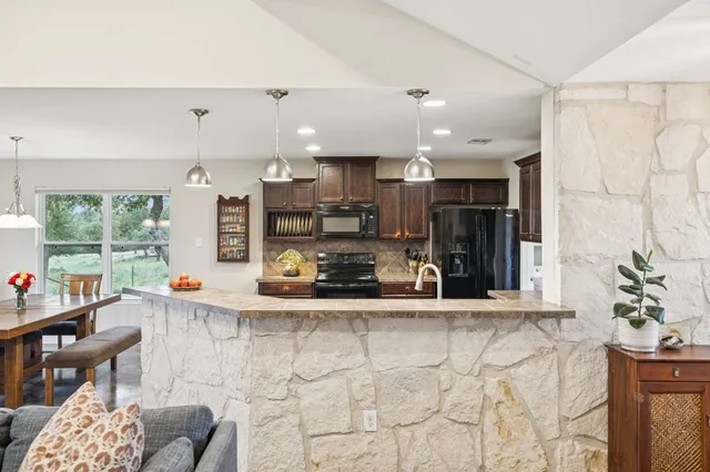 a kitchen with stainless steel appliances kitchen island granite countertop a sink and cabinets