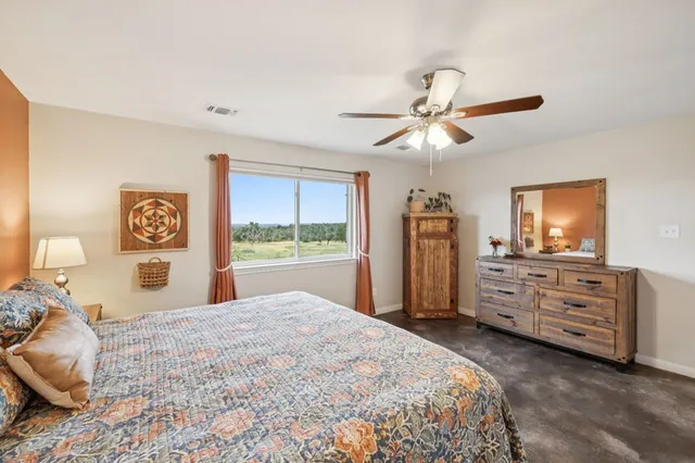 a bedroom with a bed dresser and a flat tv screen