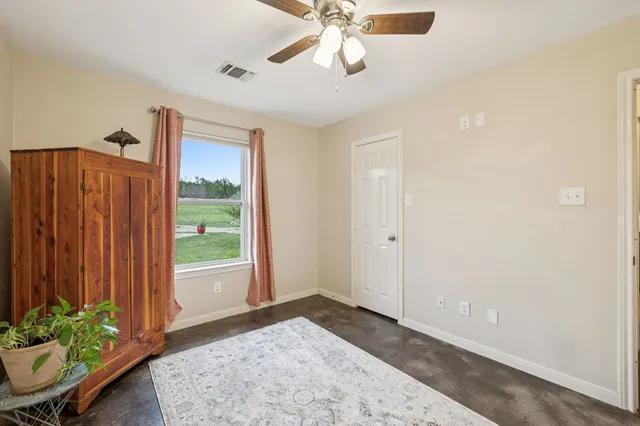 a view of a livingroom with a ceiling fan and window