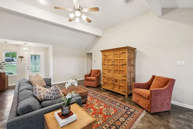 a living room with furniture a rug and a chandelier