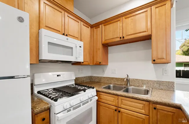 a kitchen with stainless steel appliances granite countertop a sink stove and cabinets
