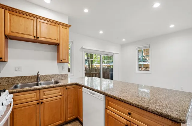 a kitchen with granite countertop cabinets sink and window