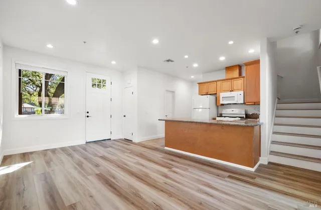 a view of kitchen with stainless steel appliances granite countertop a stove and a refrigerator