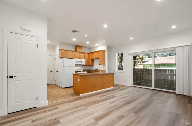 a large kitchen with stainless steel appliances granite countertop a refrigerator and a stove top oven