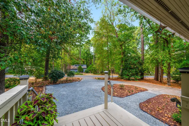 an empty room with wooden floor a fireplace and windows