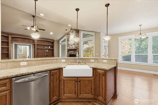a kitchen with kitchen island granite countertop a sink island and a wooden floors