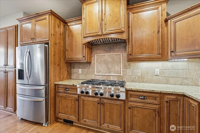a kitchen with stainless steel appliances granite countertop a refrigerator stove and sink