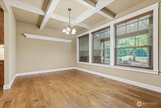 a view of an empty room with a window and chandelier