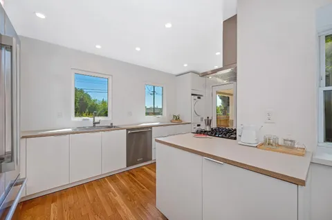 a kitchen with sink cabinets and wooden floor
