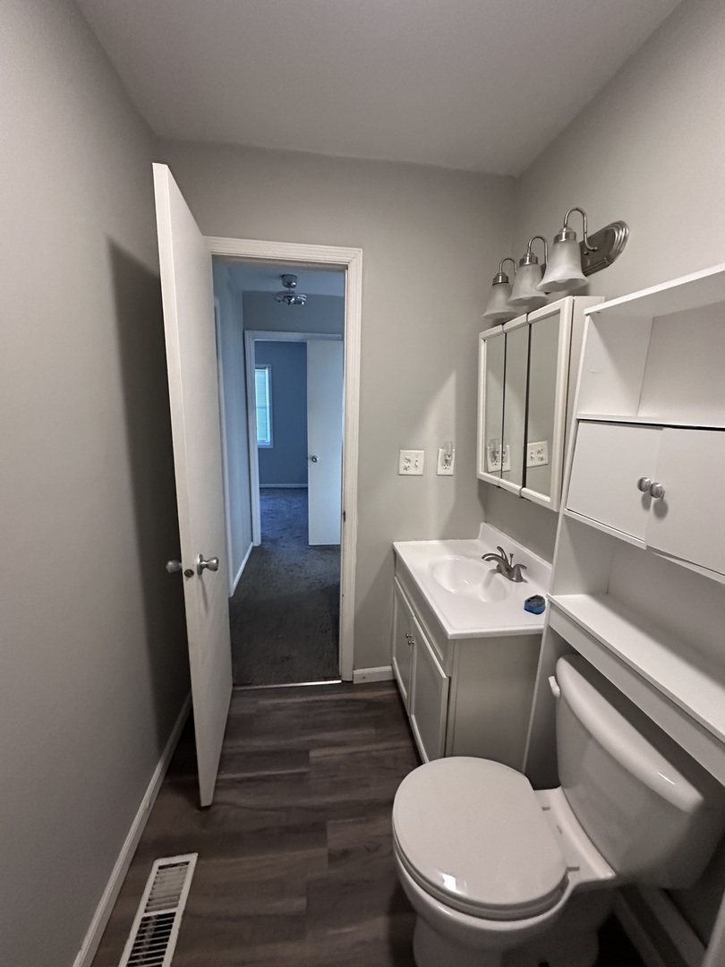 100 West 3rd Street Sublette, IL 61367 - Photo 14 of 18 a white toilet sitting next to a bathroom sink