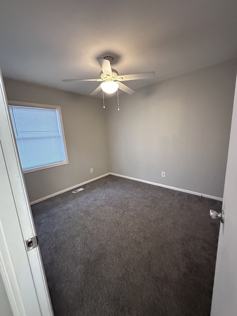 100 West 3rd Street Sublette, IL 61367 - Photo 16 of 18 an empty room with a window and a ceiling fan