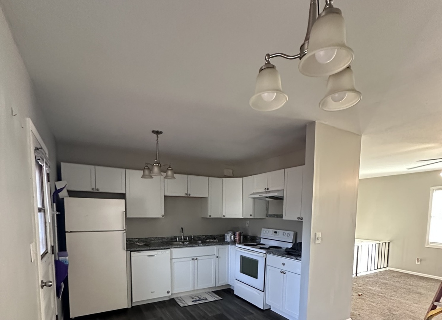 100 West 3rd Street Sublette, IL 61367 - Photo 4 of 18 a kitchen with kitchen island white cabinets and white appliances