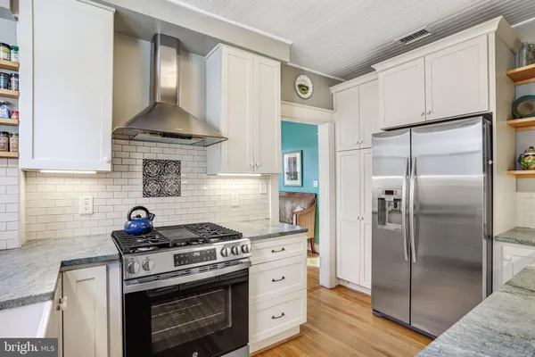 a kitchen with stainless steel appliances a stove a refrigerator and a sink