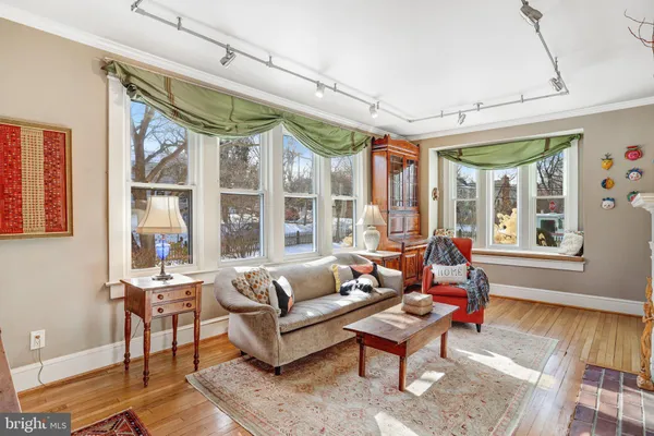 a living room with furniture a large window and wooden floor