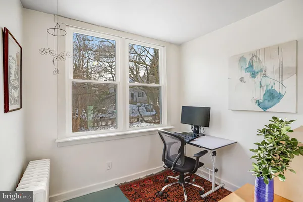 a view of a workspace with furniture and a window